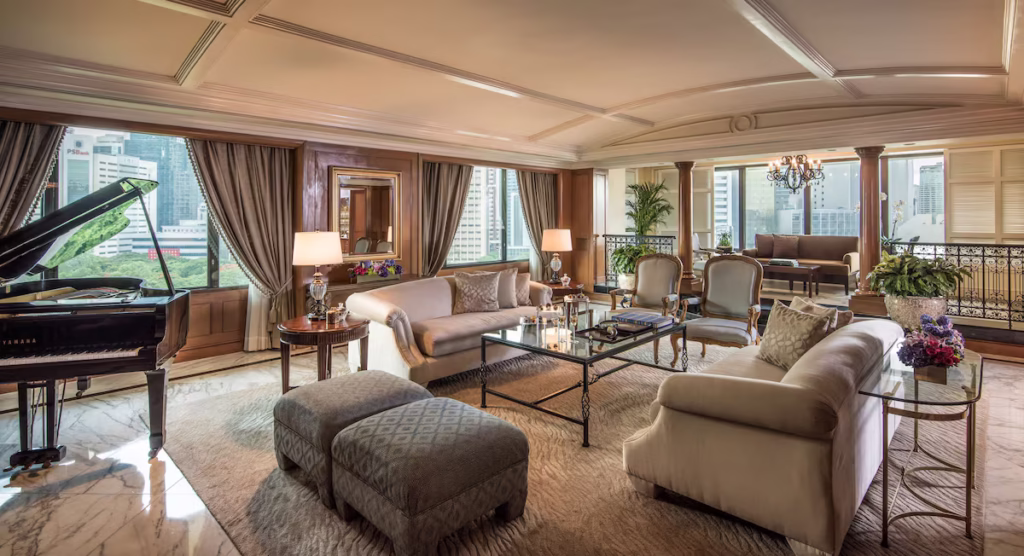 The Peninsula Manila suite with a spacious living room, grand piano, and large windows overlooking the city