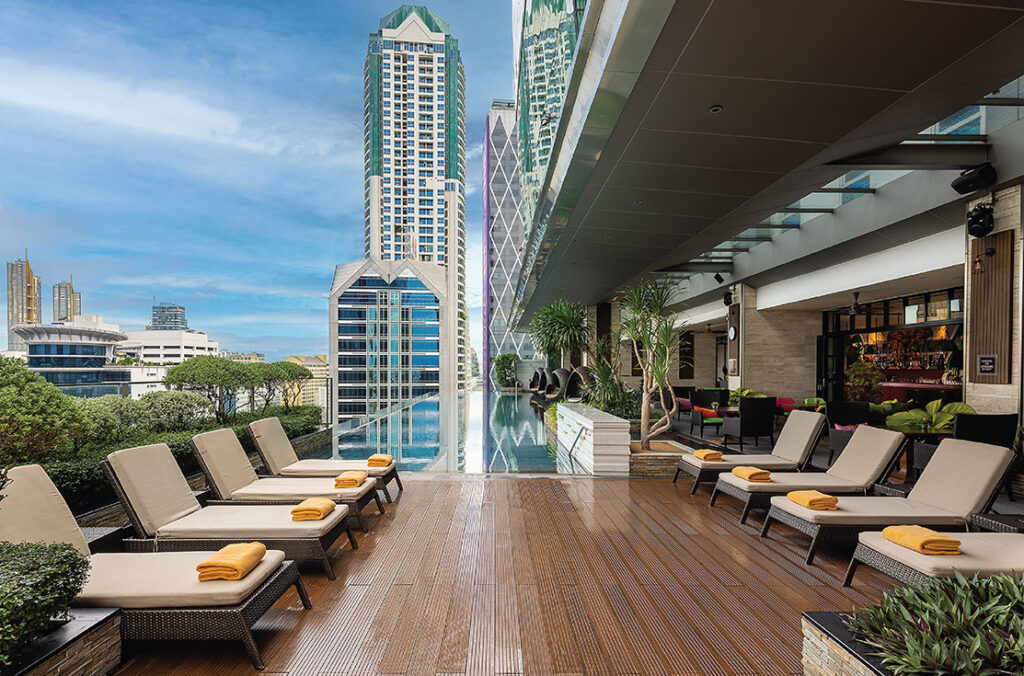 Infinity pool at Eastin Grand Hotel Sathorn with lounge area and city views