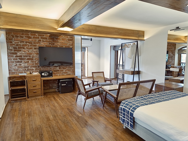 Where To Stay For a Soft Landing In India 12 Abode Bombay, room with a accent brick wall and conversation area