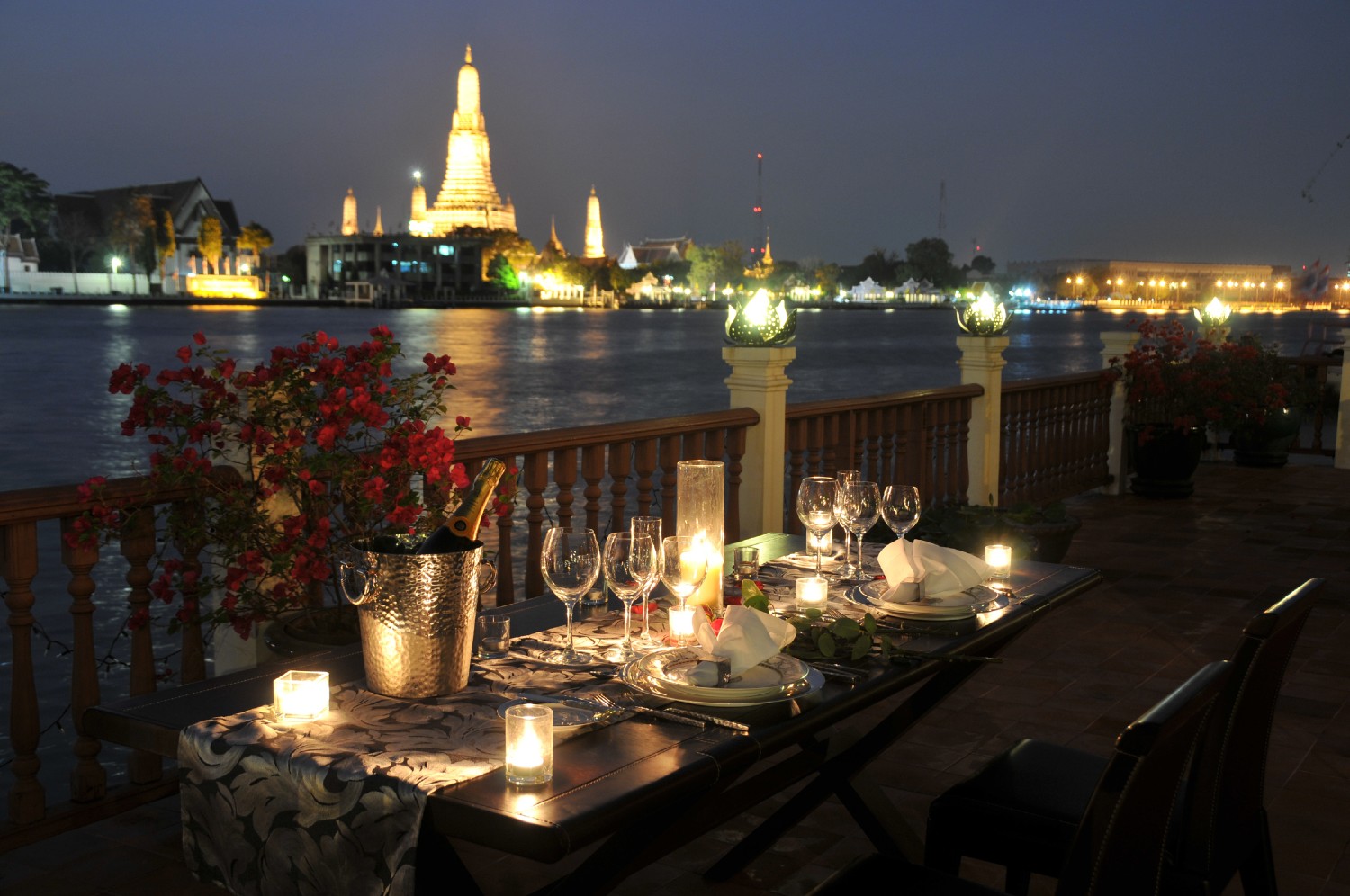 Chakrabongse Villas dining balcony, with view of Wat Arun lit up at night