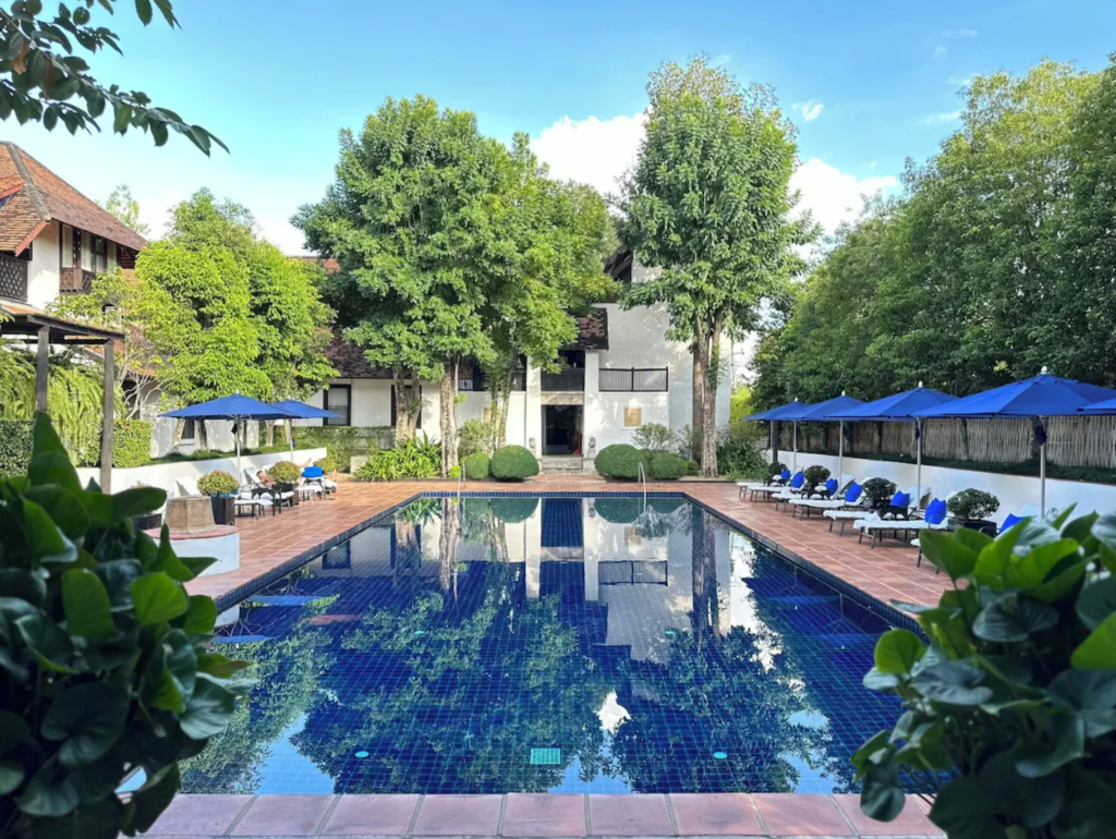 Pool and lounge area at Rachamankha Hotel surrounded by greenery