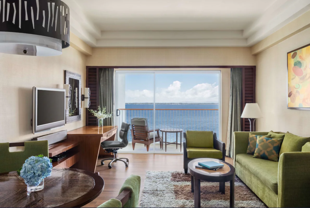 Shangri-La Mactan, suite with a living room, work desk, and sea views