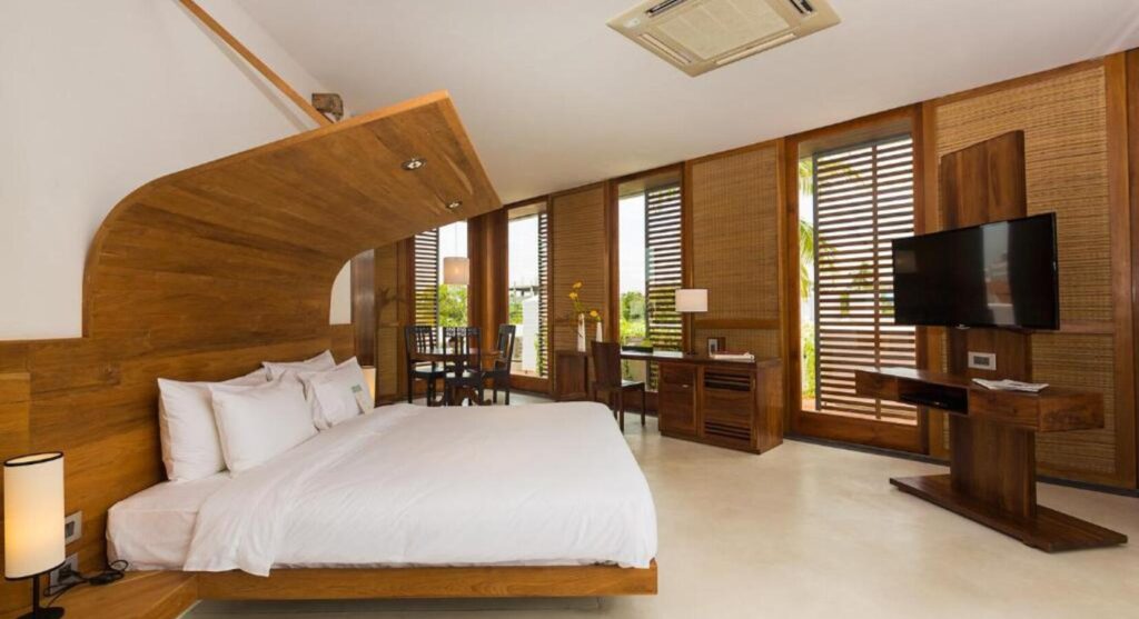 Where To Stay For a Soft Landing In India 55 La Villa, room with a curved wooden headboard and floor-to-ceiling windows
