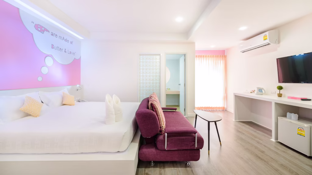 The Tint, room with pink accent wall and seating area