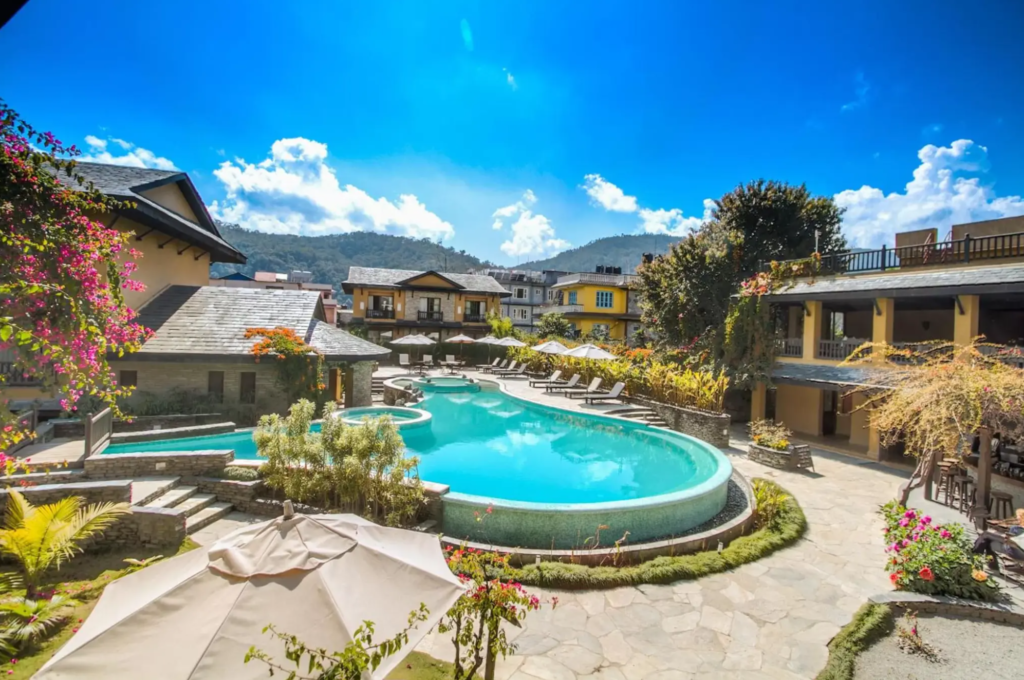 Pool And Lounge Area At Temple Tree Resort & Spa With Mountains At The Back