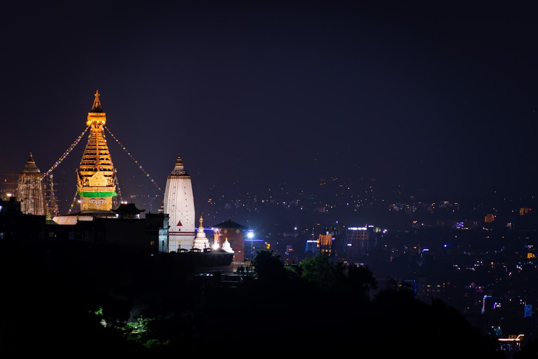 View Of Swayambhu Mahachaitya "The Monkey" Temple At Night With The City At The Back