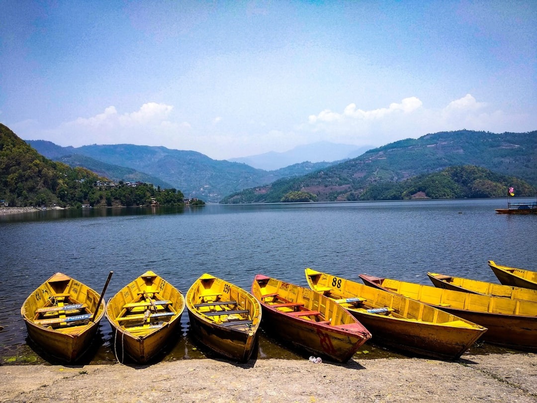 Street View Of Begnas Lake With Traditional Nepali Boats And The Mountains Surrounding The Lake