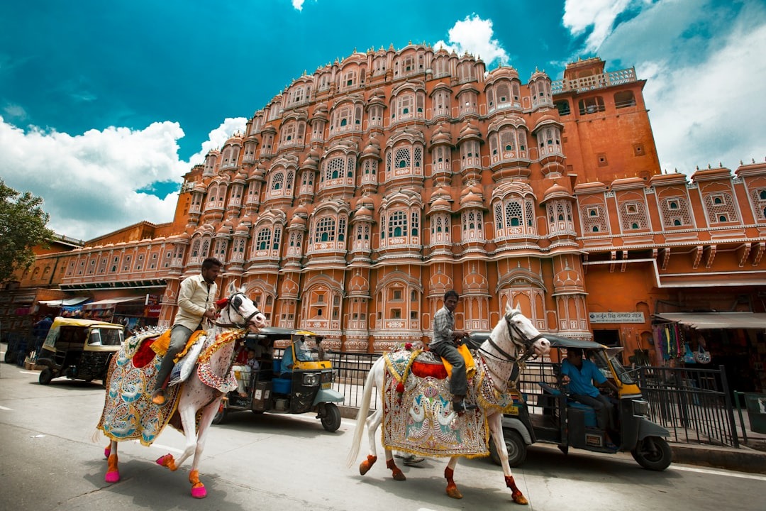 Where To Stay For a Soft Landing In India 13 Street view of Hawa Mahal in Jaipur with decorated horses and auto rickshaws in front